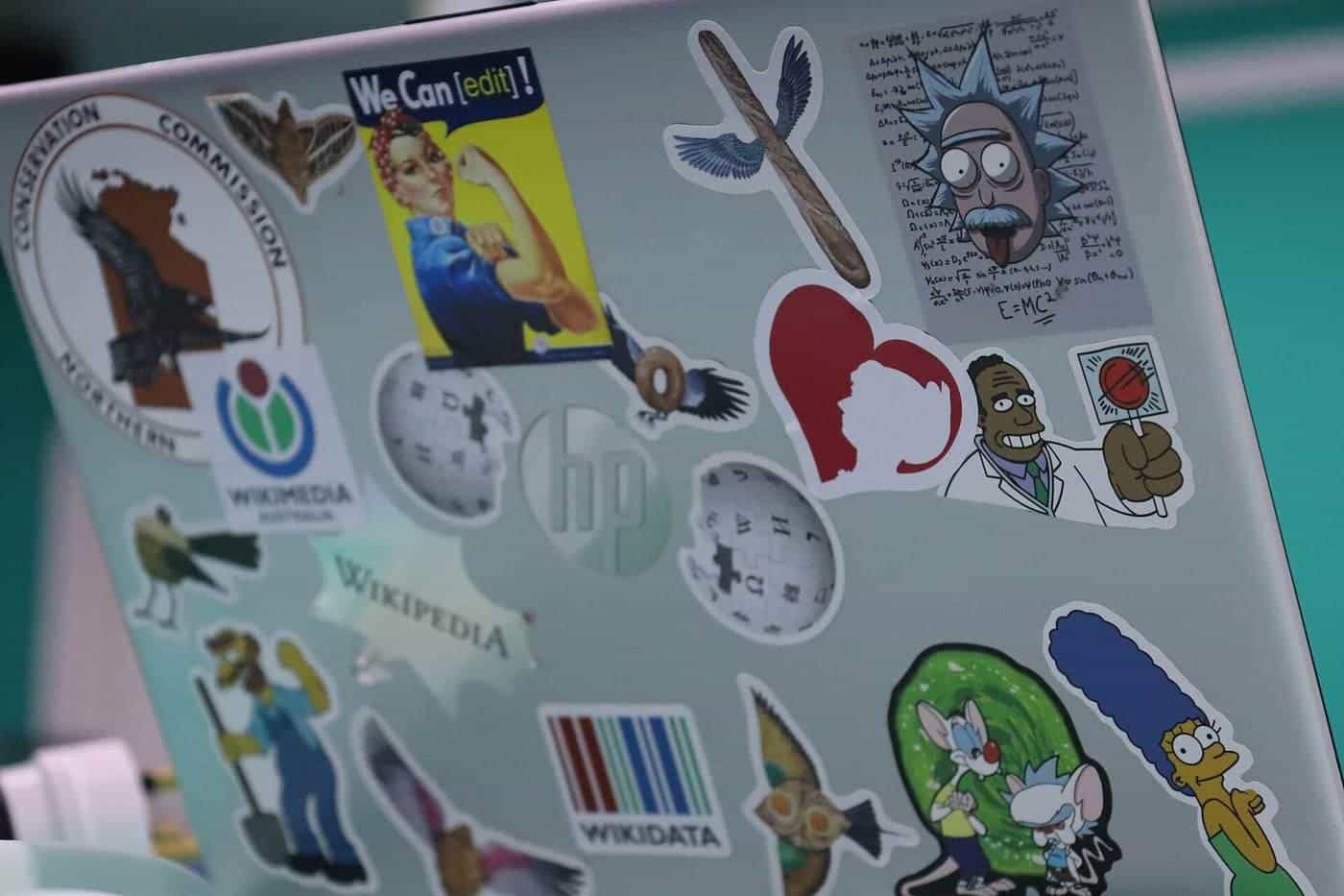 Colourful stickers of logos and cartoon characters on a laptop lid